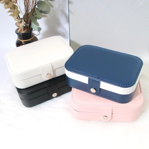 Portable PU leather jewelry organizer boxes in four colors on a white plush rug