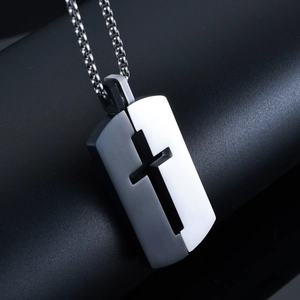 Gros plan du pendentif croix ajouré en acier inoxydable bicolore noir et argenté poli