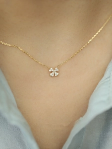 Close-up of a 14k gold-plated 925 silver clover pendant necklace with micro-pave crystals