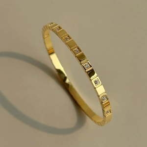 Detalle macro de la pulsera chapada en oro de 18k con cuadrados geométricos y circonitas