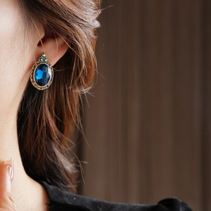 Gros plan de boucles d'oreilles vintage avec pierre bleue et incrustations argentées