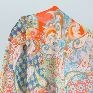 Close-up of vibrant paisley print beach cover-up with intricate fabric texture
