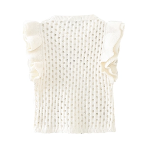 Détail du gilet tricoté blanc crème avec motifs ajourés et volants décoratifs sur les bords