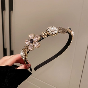 Close-up of golden headband with luxury pearls, crystals, and floral bee motifs