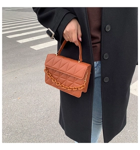 Gros plan du sac matelassé marron avec chaîne en résine épaisse en style urbain extérieur