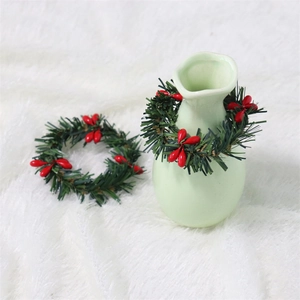 Christmas candle ring with green pine needles and red berries on white plush background