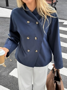 Navy blue double-breasted jacket with gold buttons in casual street style outdoors
