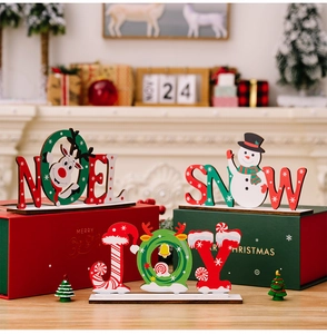 Dettaglio delle insegne natalizie NOEL, SNOW e JOY in legno sul caminetto