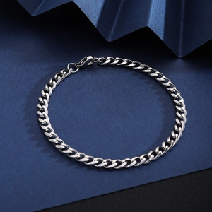 Detailed close-up of a silver stainless steel Cuban link bracelet with a lobster clasp
