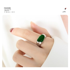 Detail of a vintage silver stainless steel ring featuring a smooth emerald green stone inlay