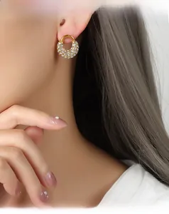 Gros plan de boucles d'oreilles en U dorées avec cristaux sertis sur le modèle