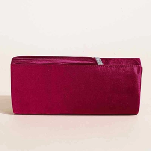 Dettaglio macro della pochette da sera in raso fucsia scuro con fibbia in strass lucidi