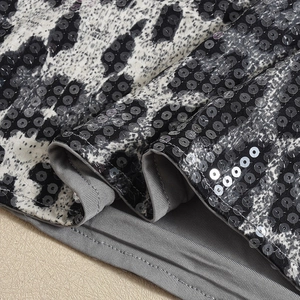 Détail de paillettes léopard haute densité et coutures fines sur une robe moulante