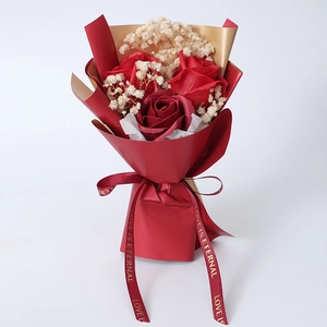 Detail of red soap rose bouquet with baby's breath and Love is Eternal ribbon