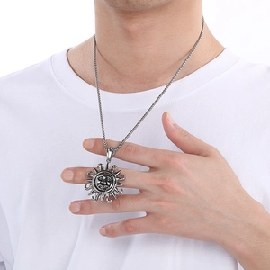 Close-up of vintage sun totem pendant in silver finish on a stainless steel chain