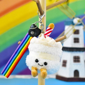 Adorable smiling plush cake keychain accessory featuring a vibrant rainbow strap