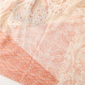 Detailed view of orange and beige paisley patterns on lightweight linen cotton scarf