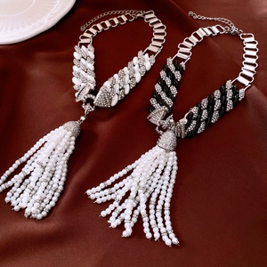 Macro view of vintage silver tassel necklace with white pearls and sparkling rhinestones
