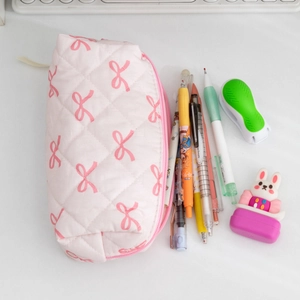 Detail of pink bow pattern on quilted fabric stationery pouch with desktop accessories