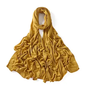 Detailed view of mustard yellow modal cotton jersey scarf with fine overlock stitched edges
