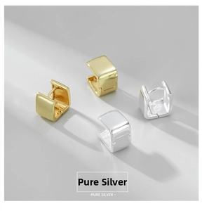 Macro shot of polished S925 sterling silver square earrings in gold and silver