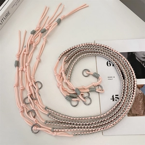 Detail of adjustable hand-woven pink and grey shoulder strap with metal ring buckle