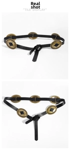Detail of black vintage waist belt featuring gold embossed metal discs in bohemian style