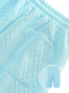 Macro shot of light blue shorts showing waffle knit texture and drawstring waistband