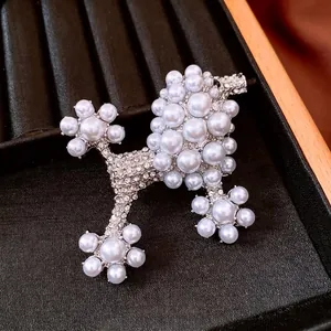 Elegant poodle brooch with white pearls and sparkling rhinestones on a silver frame