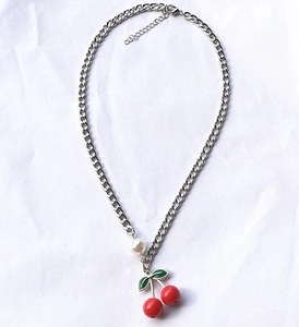 Minimalist silver chain necklace featuring red cherry pendants and a white pearl accent