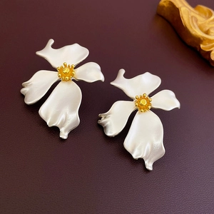 Detail of vintage flower stud earrings with silver frosted petals and golden centers