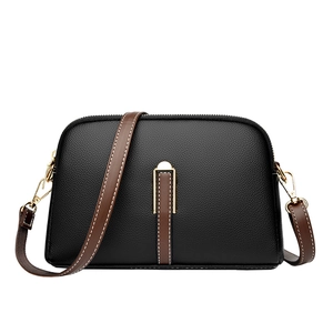 Classic black leather shell crossbody bag with brown strap and golden hardware