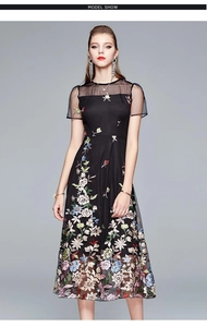 Detail of black mesh patchwork and delicate colorful floral embroidery on high-waist dress