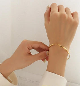 Detailed view of a gold twisted cuff bracelet showing the polished metal finish and wavy shape