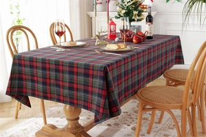 Detailed view of festive red and green plaid Christmas tablecloth with decorative tassels