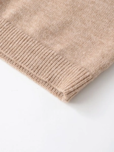 Macro view of ribbed knit cuffs on camel cashmere sweater showing soft fabric texture