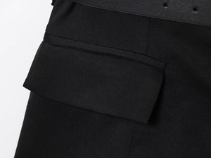 Detail of black vest fabric texture with pocket flap and matching leather belt with holes