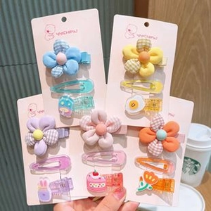 Detailed view of colorful girls' hair clips featuring cute cartoon fruit and floral patterns