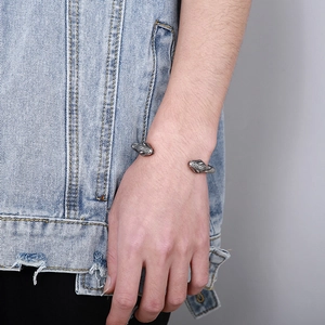Macro detail of retro punk bracelet showing dual snake head design and etched metal texture