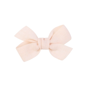 Detailed close-up of a pink fabric bow hair clip for babies with soft textile texture
