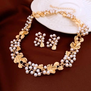 Exquisite gold floral necklace and earring set with pearls on elegant dark background