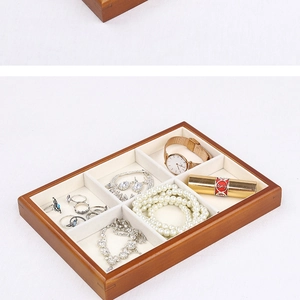 Close-up of wooden jewelry tray with 6 slots and soft beige velvet lining texture
