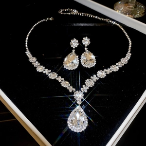 Detailed view of silver-tone square jewelry set with crystals on black velvet