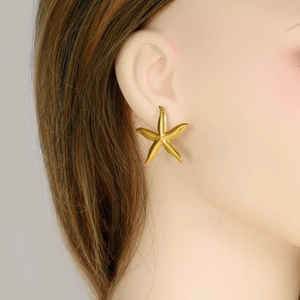 Golden starfish stud earrings in 304 stainless steel shown on a female model