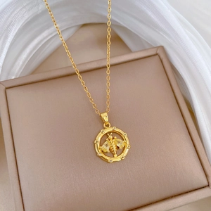 Detailed close-up of golden bee pendant with sparkling stones on a jewelry box