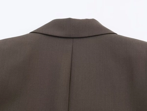Close-up of the back collar seam and twill fabric texture on a dark brown suit
