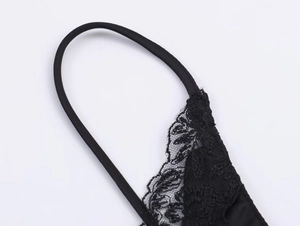 Detailed close-up of delicate black floral lace stitching and elastic strap connection