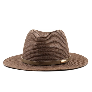 Detail of dark brown straw sun hat featuring a leather band with a golden metal buckle