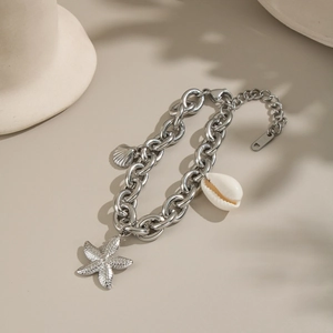 Detailed shot of silver beach charm bracelet featuring starfish and seashell pendants