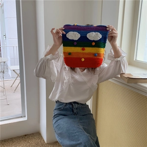 Rainbow striped hand-knitted crochet bag with colorful pom-pom and white cloud details